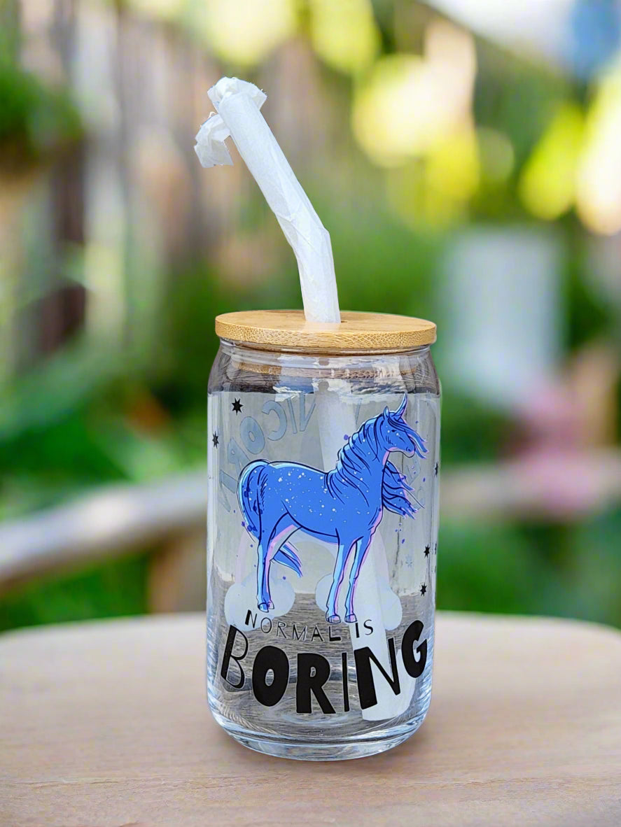 Clear tumbler with blue unicorn design and 'Boring' text on a wooden surface