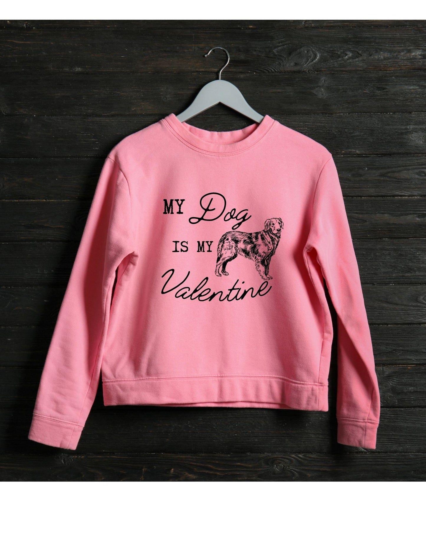 Pink sweatshirt with 'My Dog is My Valentine' text and dog illustration on a dark wooden background