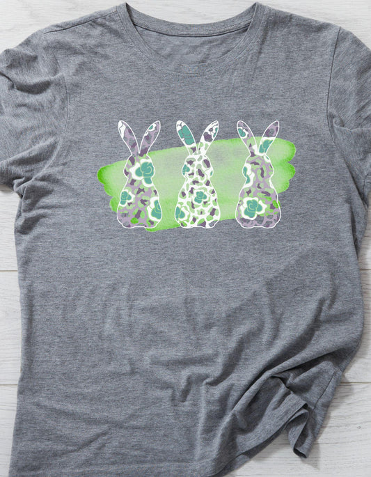 Gray t-shirt with a graphic of three bunnies on a green background