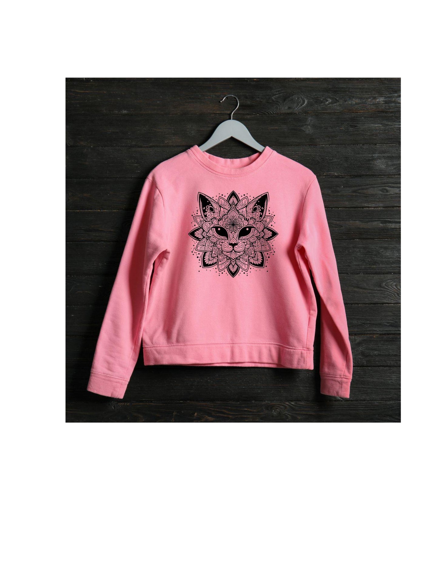 Pink sweatshirt with a black fox design on a wooden surface