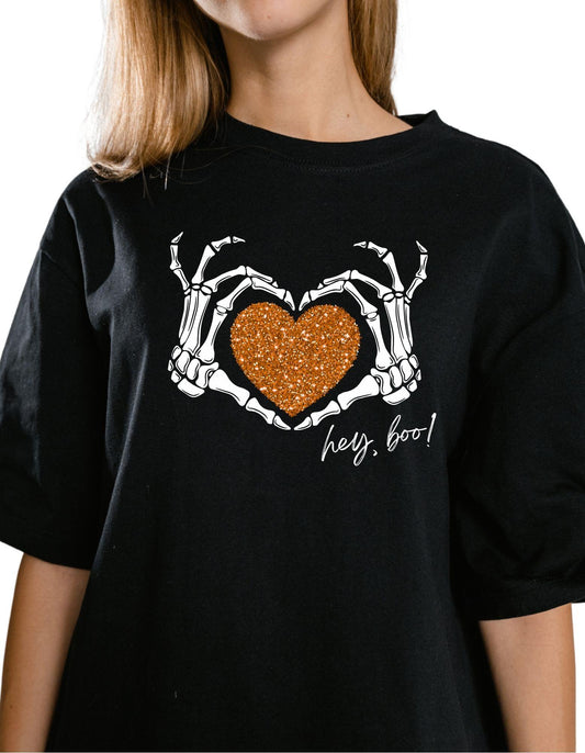 Black t-shirt with skeleton hands holding a heart and 'hey, boo!' text on a white background