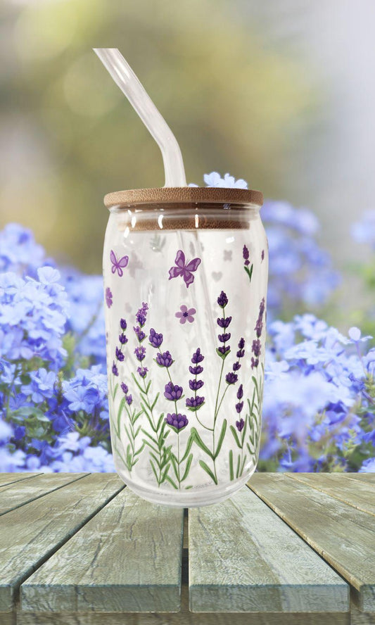 Tumbler with lavender designs on a wooden surface with blurred flowers in the background