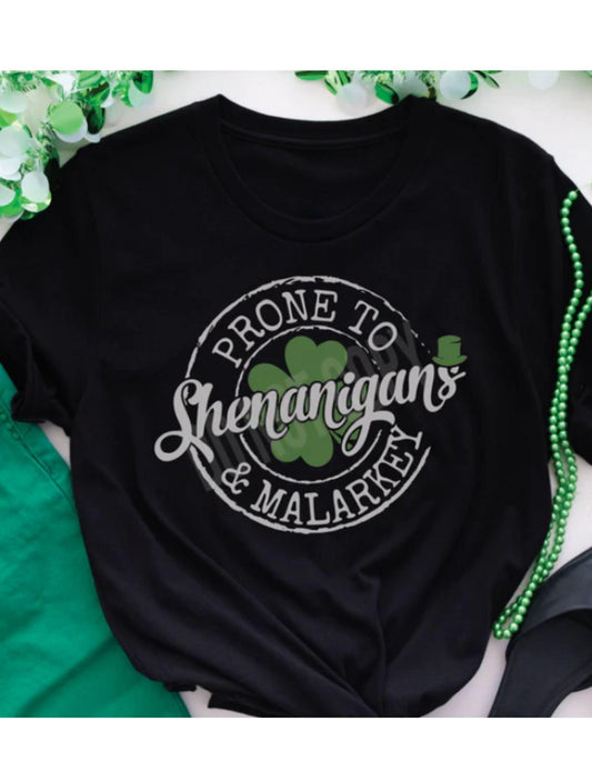 Black t-shirt with 'Prone to Shenanigans & Malarky' text and shamrock design on a green and white background.