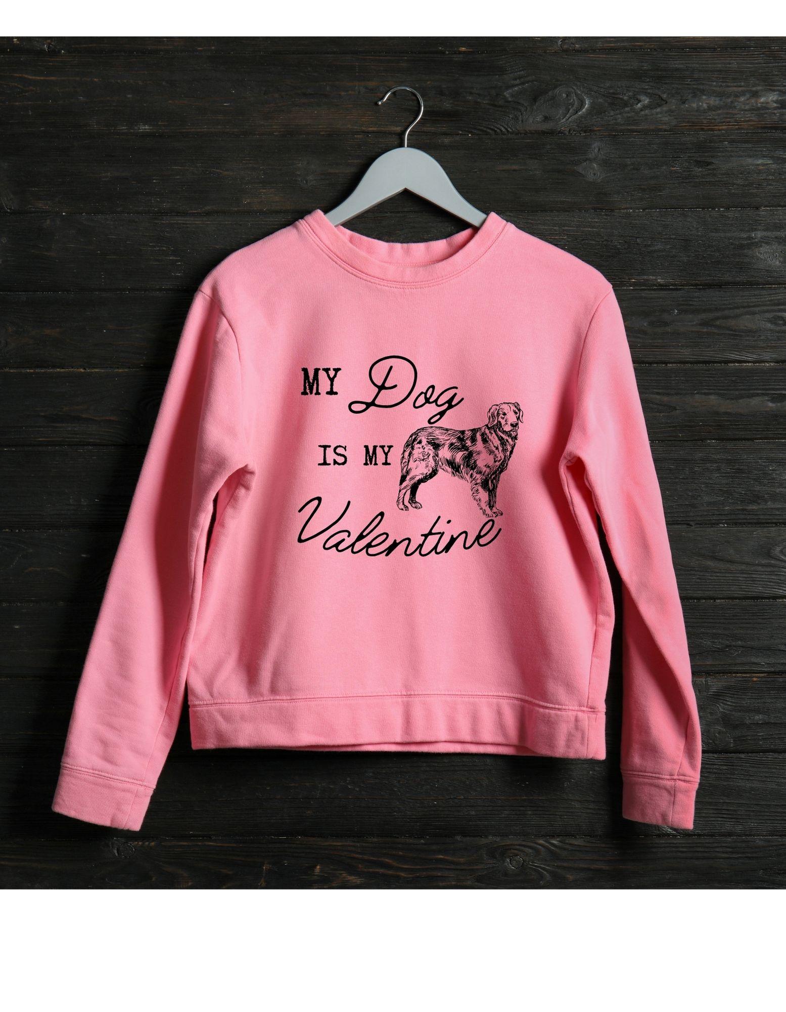 Pink sweatshirt with 'My Dog is My Valentine' text and dog illustration on a dark wooden background