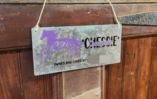 A metal stall plate with a purple horse silhouette and customized text including the name 'Chesbie'.
